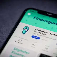 Ein Smartphone zeigt die App "Finanzguru - Konten & Verträge". Der finanzguru testet die Funktionen dieser App.