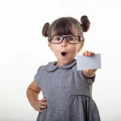 Kleines Mädchen mit Brille hält eine Karte, als ob sie ihr bling konto präsentiert.