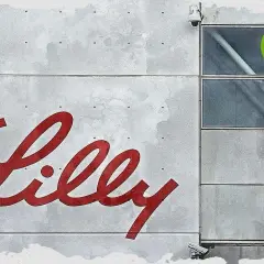 Großes rotes Lilly-Logo auf grauem Gebäude mit Fenstern und TU-Logo.