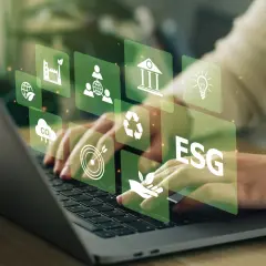 Hände tippen auf Laptop, überlagert von grünen Icons für Nachhaltigkeit und ESG-Kriterien. Investitionen in grüne energie aktien werden hier visualisiert.