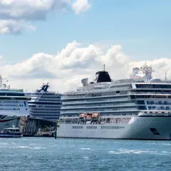 Mehrere Kreuzfahrtschiffe liegen im Hafen, ein Zeichen für die florierende Branche und gute Aussichten für Kreuzfahrt Aktien.