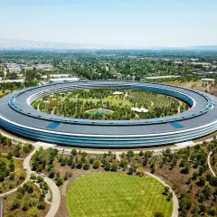 Das Apple Park Hauptquartier, ein Symbol für die reichsten Firmen der Welt, umgeben von Grünflächen und kalifornischer Landschaft.