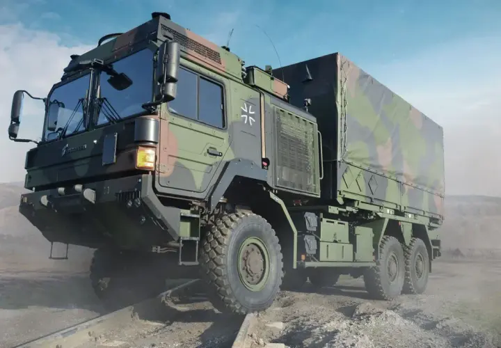 Ein schweres Militärfahrzeug von Rheinmetall, getarnt und auf unwegsamem Gelände.
