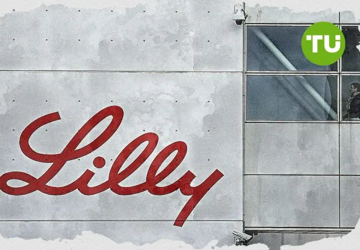 Großes rotes Lilly-Logo auf grauem Gebäude mit Fenstern und TU-Logo.