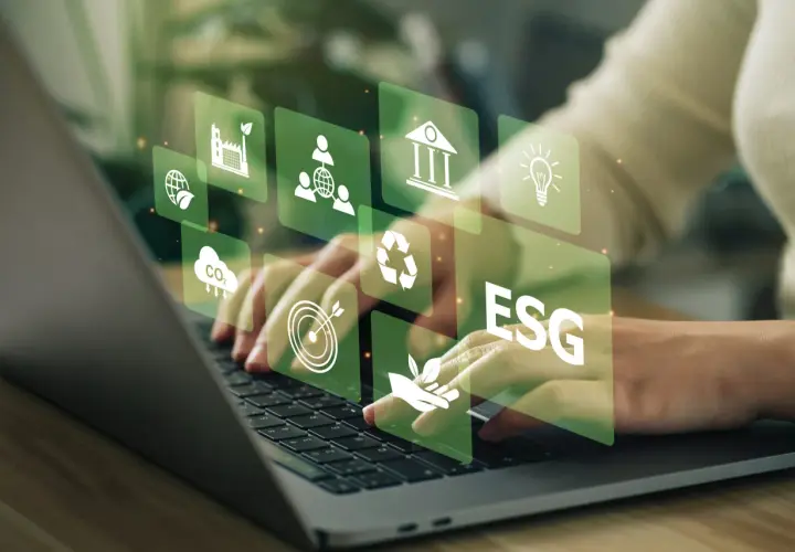 Hände tippen auf Laptop, überlagert von grünen Icons für Nachhaltigkeit und ESG-Kriterien. Investitionen in grüne energie aktien werden hier visualisiert.