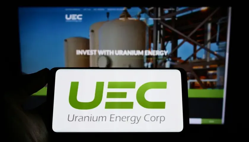 UEC Logo auf Smartphone. Hintergrund zeigt "Invest with Uranium Energy". Spannende uranium energy aktie prognose 2030?