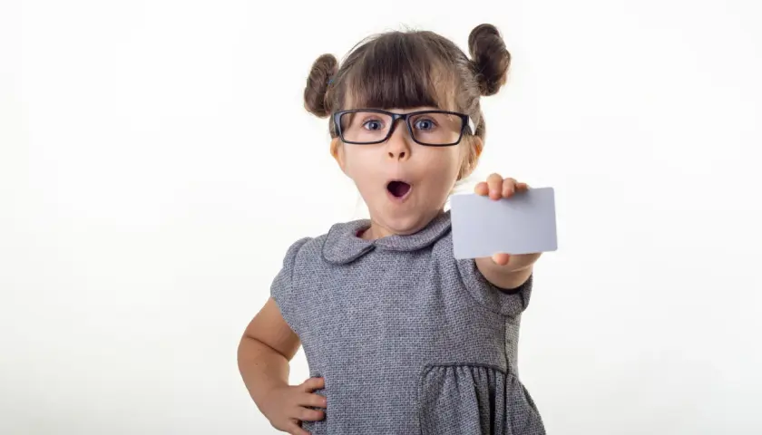 Kleines Mädchen mit Brille hält eine Karte, als ob sie ihr bling konto präsentiert.
