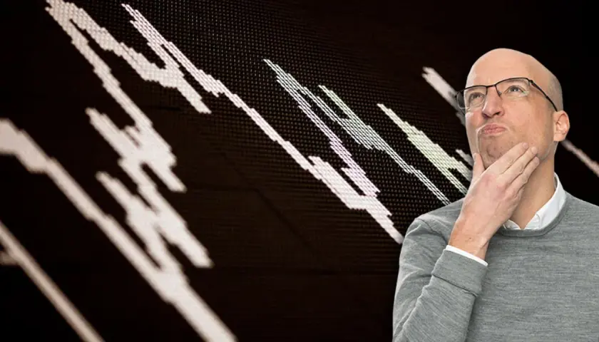 Mann denkt nach über deutsche Aktien, während ein Börsenchart im Hintergrund zu sehen ist.
