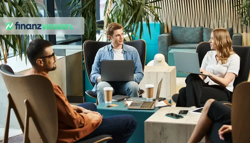 Menschen diskutieren über Finanzwissen, vielleicht über Amundi oder iShares, in einem modernen Büro mit Laptops und Kaffee.