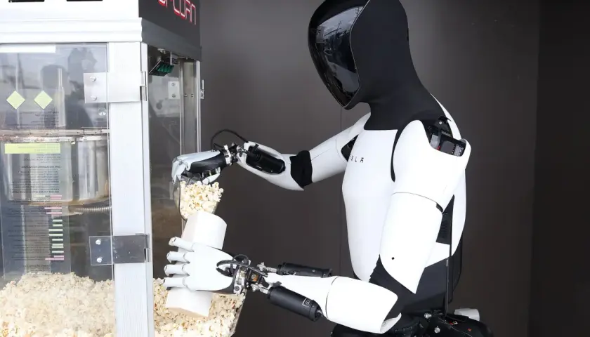 Ein humanoider Roboter füllt Popcorn in eine Tüte. Die Robotik-Aktie könnte bald solche Helfer einsetzen.