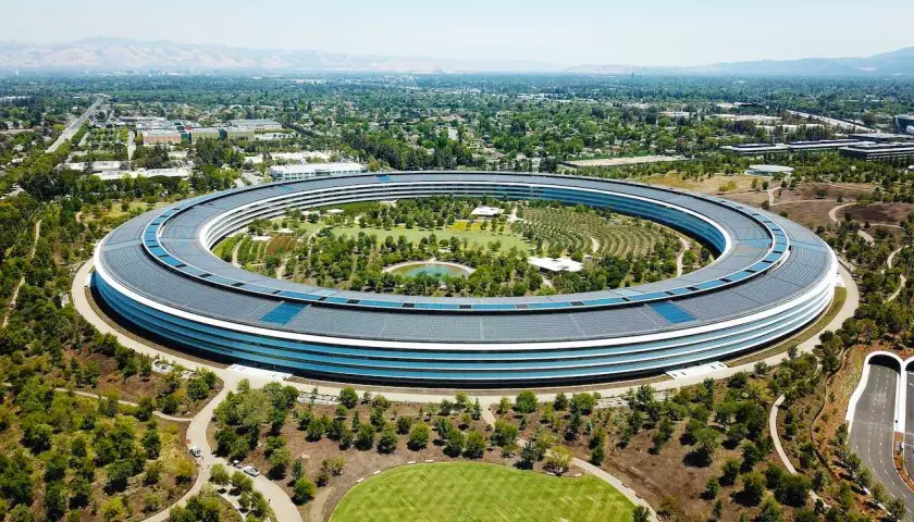 Das Apple Park Hauptquartier, ein Symbol für die reichsten Firmen der Welt, umgeben von Grünflächen und kalifornischer Landschaft.