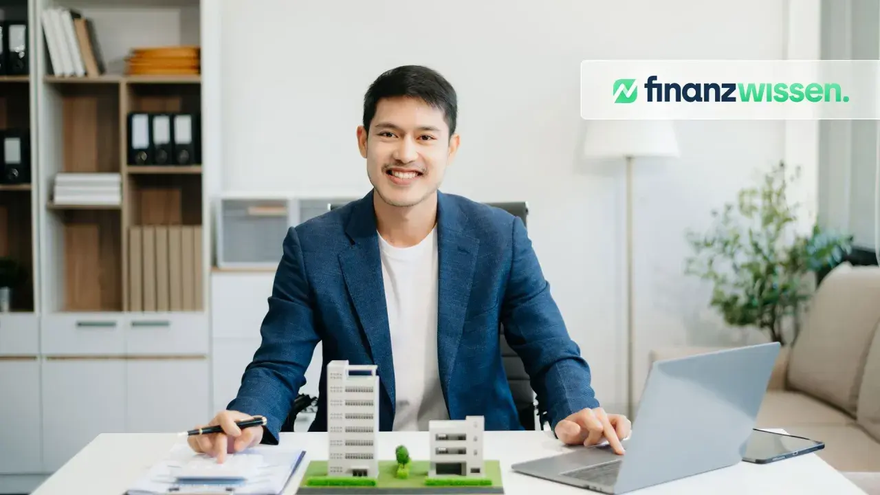 Ein Mann plant seine reits monatliche dividende mit Immobilienmodellen und einem Laptop.