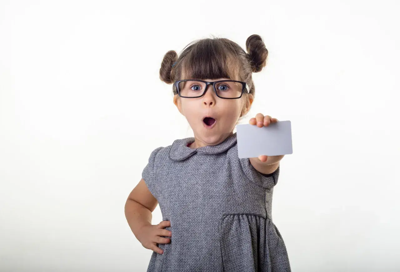 Kleines Mädchen mit Brille hält eine Karte, als ob sie ihr bling konto präsentiert.