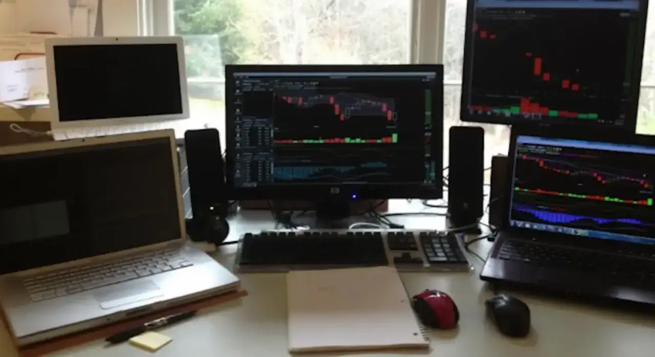 Mehrere Monitore zeigen B&ouml;rsencharts. Ein Arbeitsplatz, bereit, um Trader zu werden.